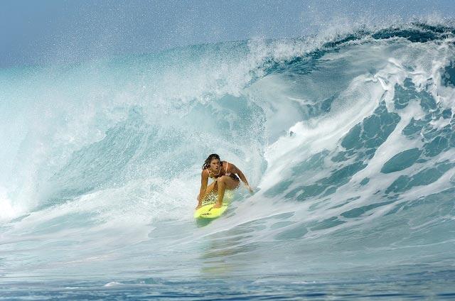 Photo of Jam Star touching the wall of a giant wave.